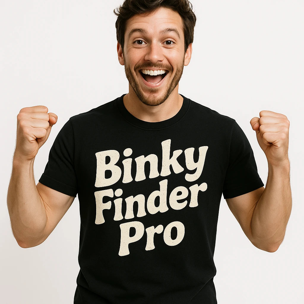Close-up of the "Binky Finder Pro" cream print on a premium Bella+Canvas black baby gear chaos t shirt