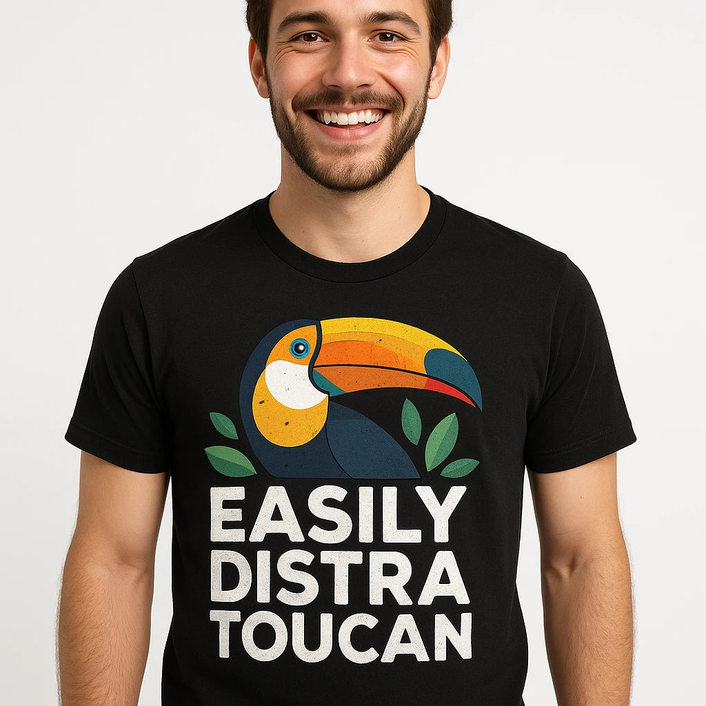 Close-up of the "Easily Distra Toucan" white print on a premium Bella+Canvas black toucan t shirt