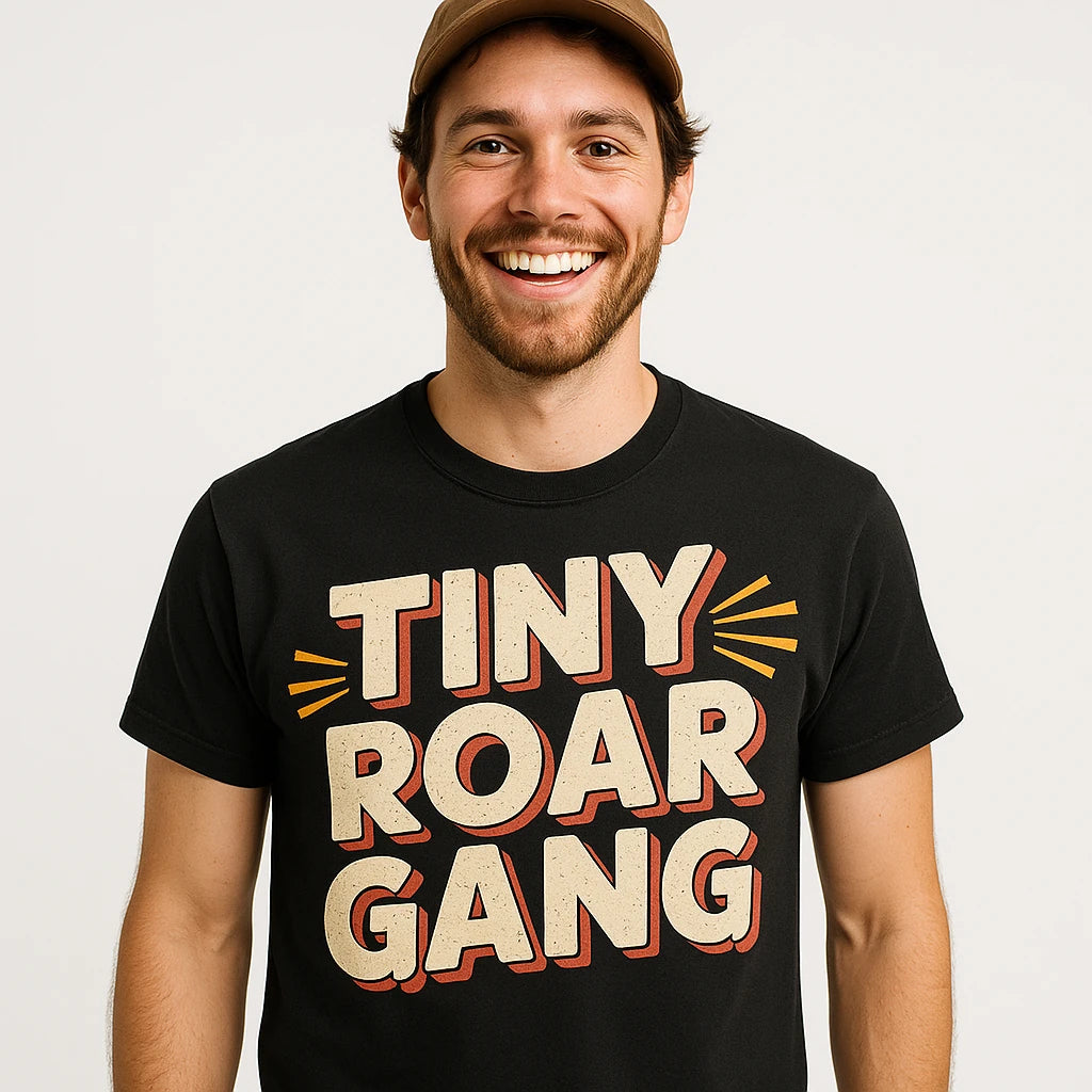 Close-up of the "Tiny Roar Gang" beige print on a premium Bella+Canvas black bobcats t shirt