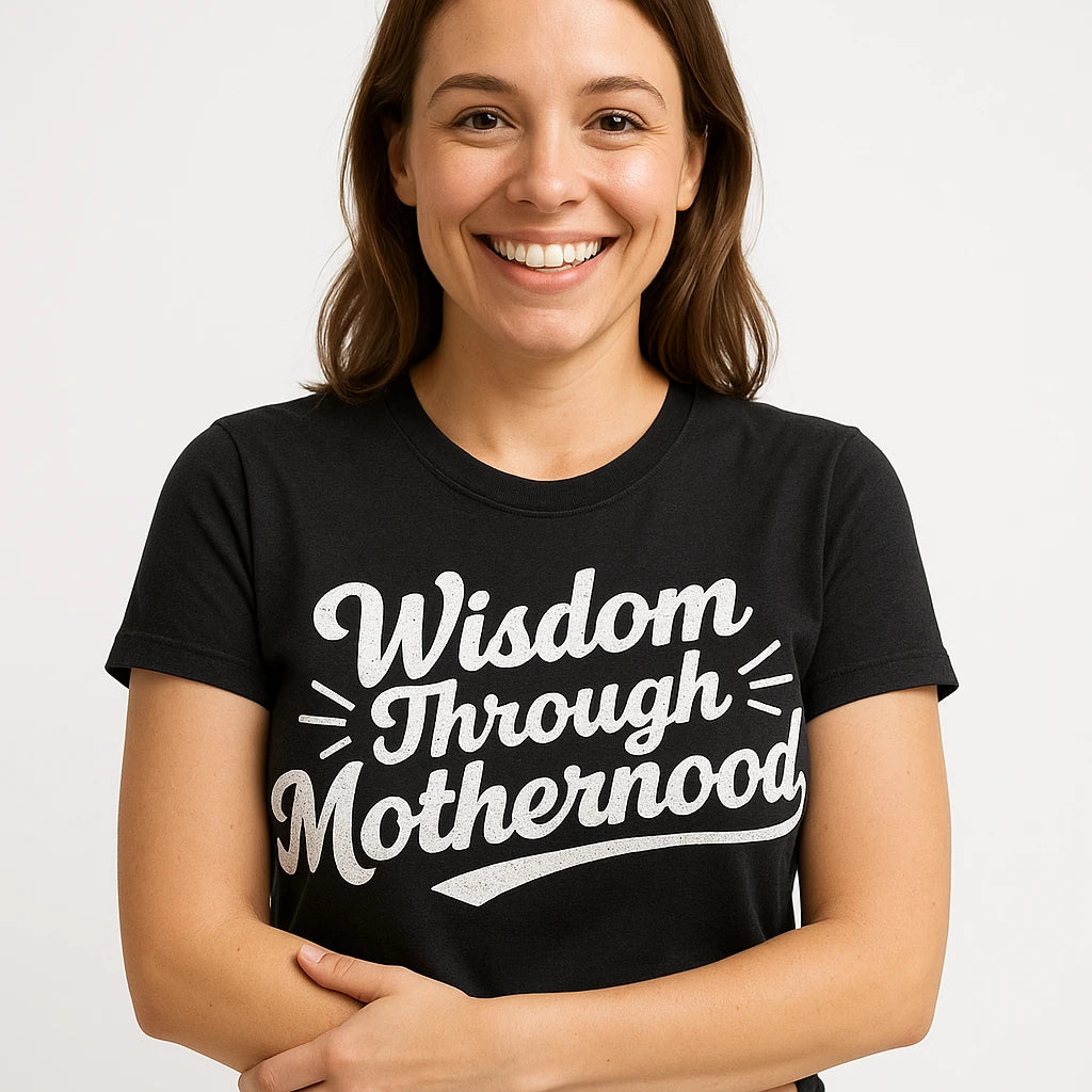Close-up of the "Wisdom Through Motherhood" white print on a premium Bella+Canvas black mama life t shirt
