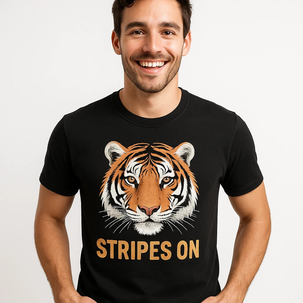 Close-up of the "Stripes On" gold print on a premium Bella+Canvas black tiger shirts