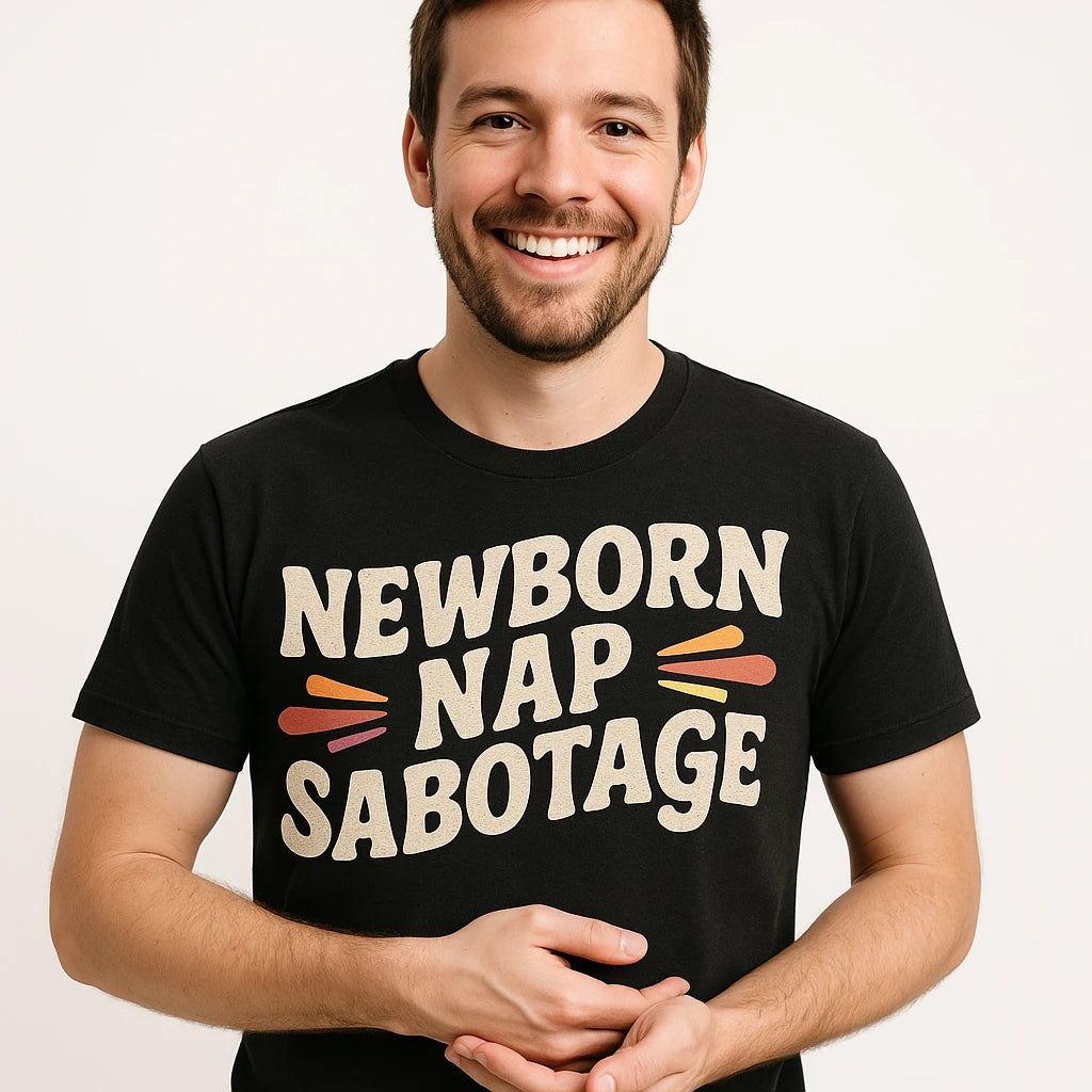 Close-up of the "Newborn Nap Sabotage" beige print on a premium Bella+Canvas black shirts for expecting parents