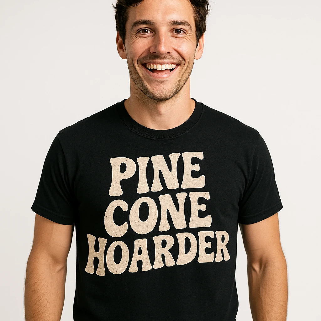 Close-up of the "Pine Cone Hoarder" beige print on a premium Bella+Canvas black nature walk shirts