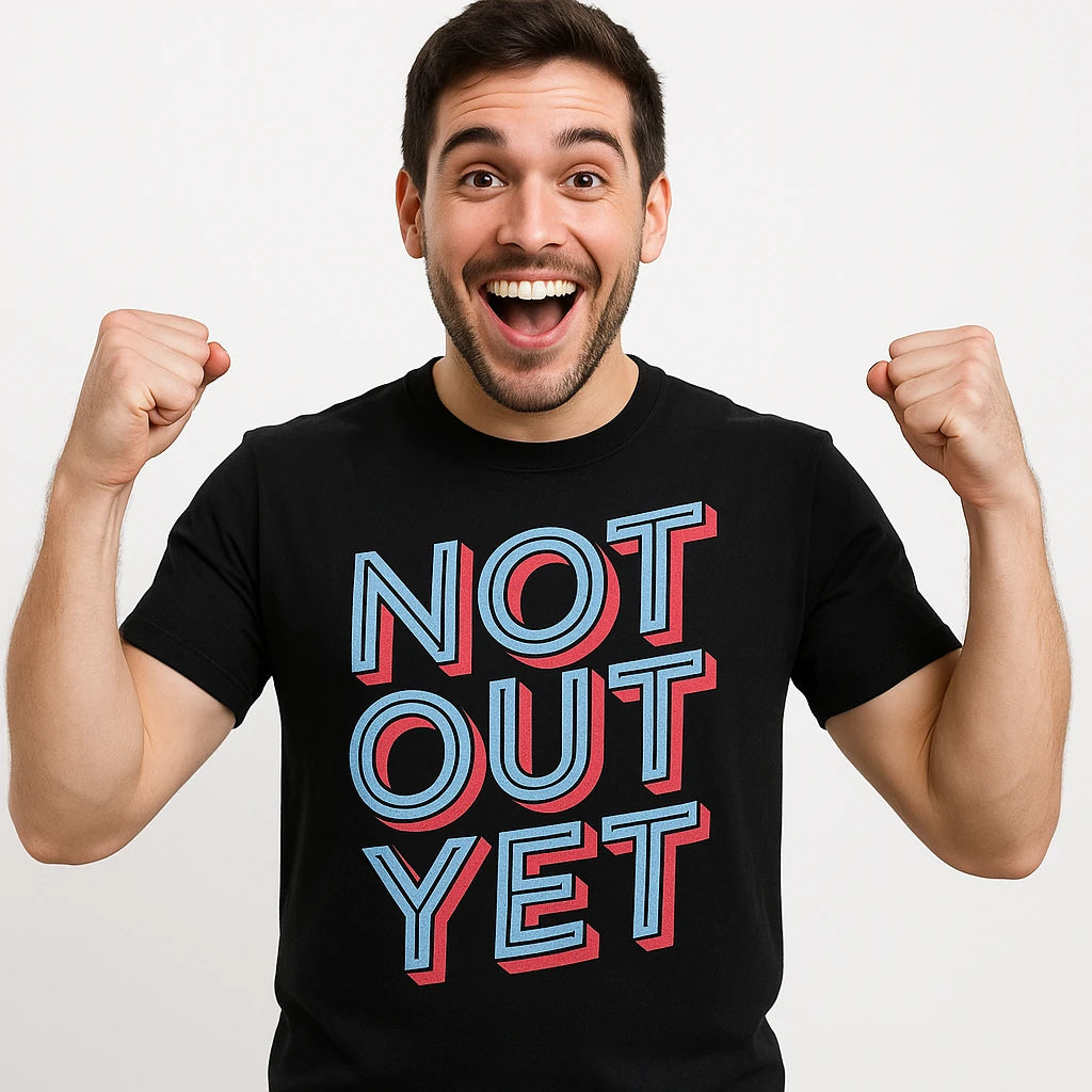 Close-up of the "Not Out Yet" light gray print on a premium Bella+Canvas black cricket shirts