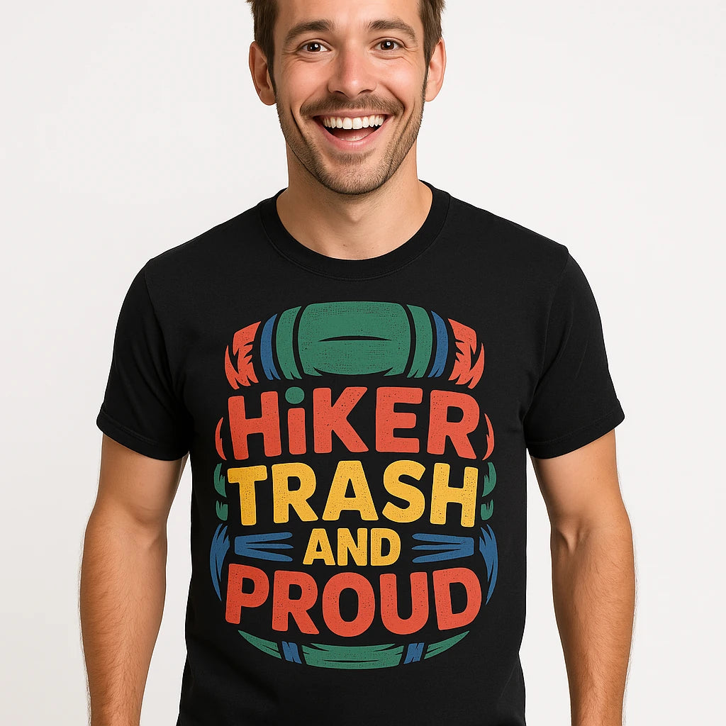 Close-up of the "Hiker Trash and Proud" orange print on a premium Bella+Canvas black backpacking t shirt