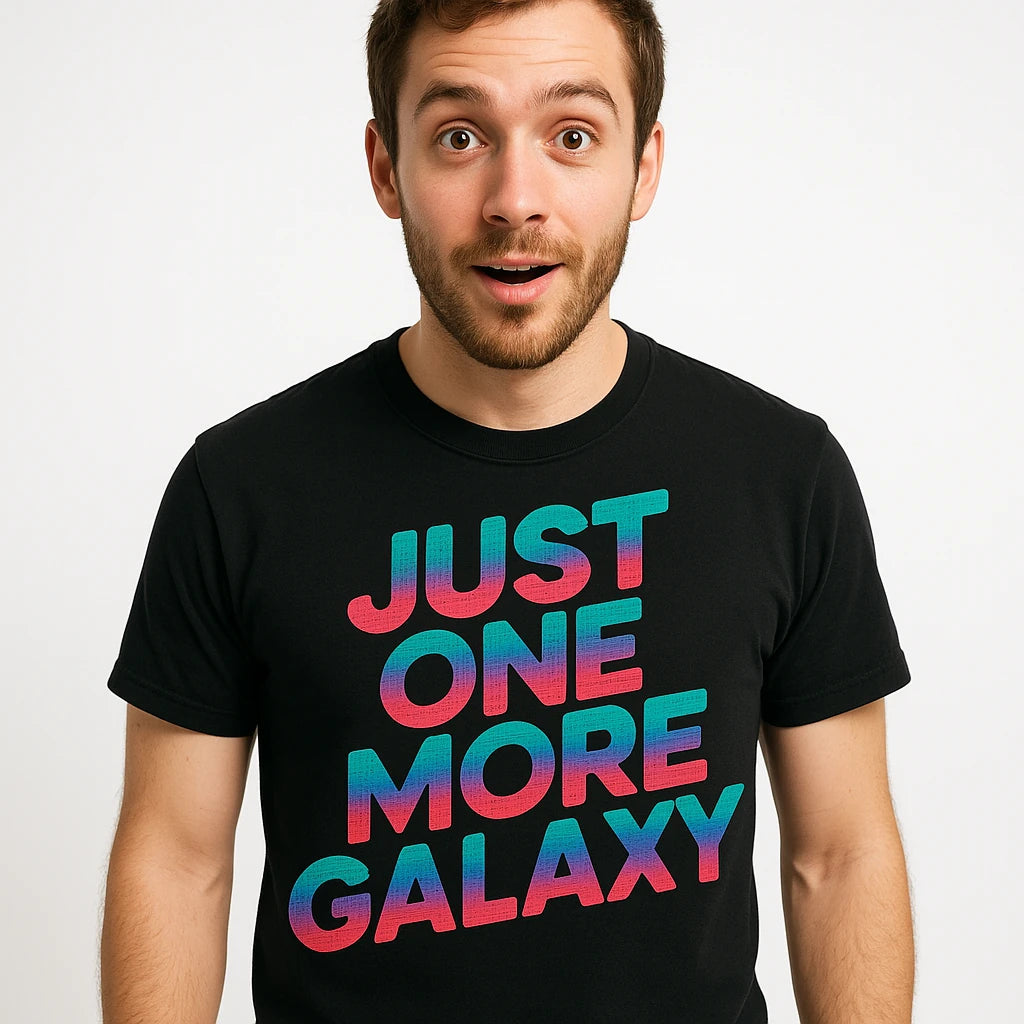 Close-up of the "Just One More Galaxy" teal print on a premium Bella+Canvas black stargazing shirts