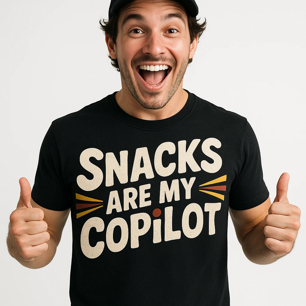 Close-up of the "Snacks Are My Copilot" cream print on a premium Bella+Canvas black adventure t shirt