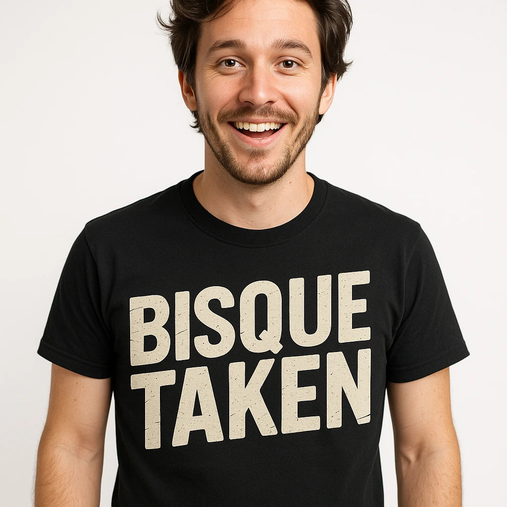 Close-up of the "Bisque Taken" beige print on a premium Bella+Canvas black ceramic tee