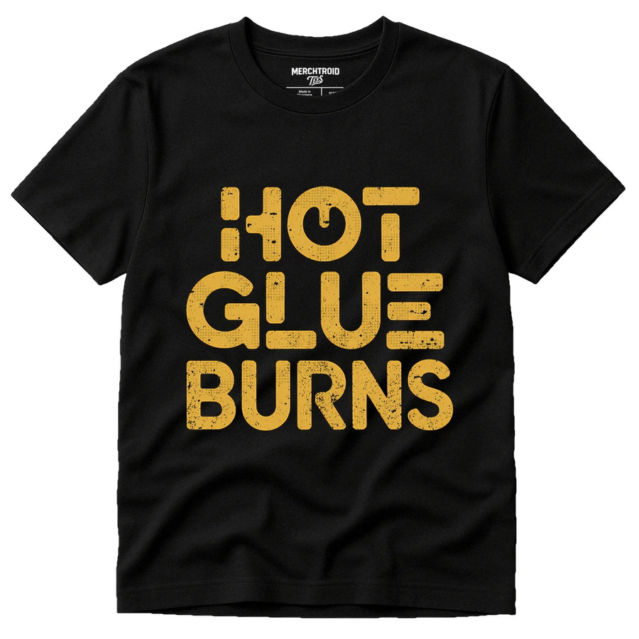 A black t-shirt with the words "HOT GLUE BURNS" printed in bold, distressed yellow letters.