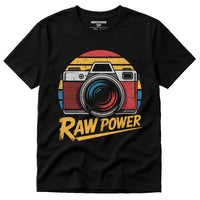 A black T-shirt featuring a vintage-style camera graphic with a sunburst background in red, yellow, and blue. The words 