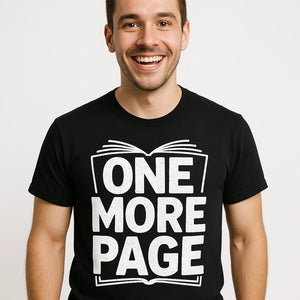 Close-up of the "One More Page" white print on a premium Bella+Canvas black reading tee shirts