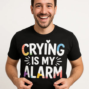 Close-up of the "Crying Is My Alarm" white print on a premium Bella+Canvas black new parents shirts
