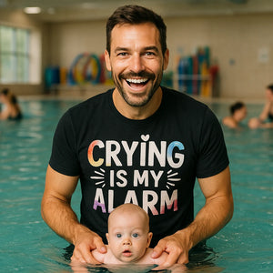 Lifestyle shot of the "Crying Is My Alarm" black new parents shirts in a real-world setting