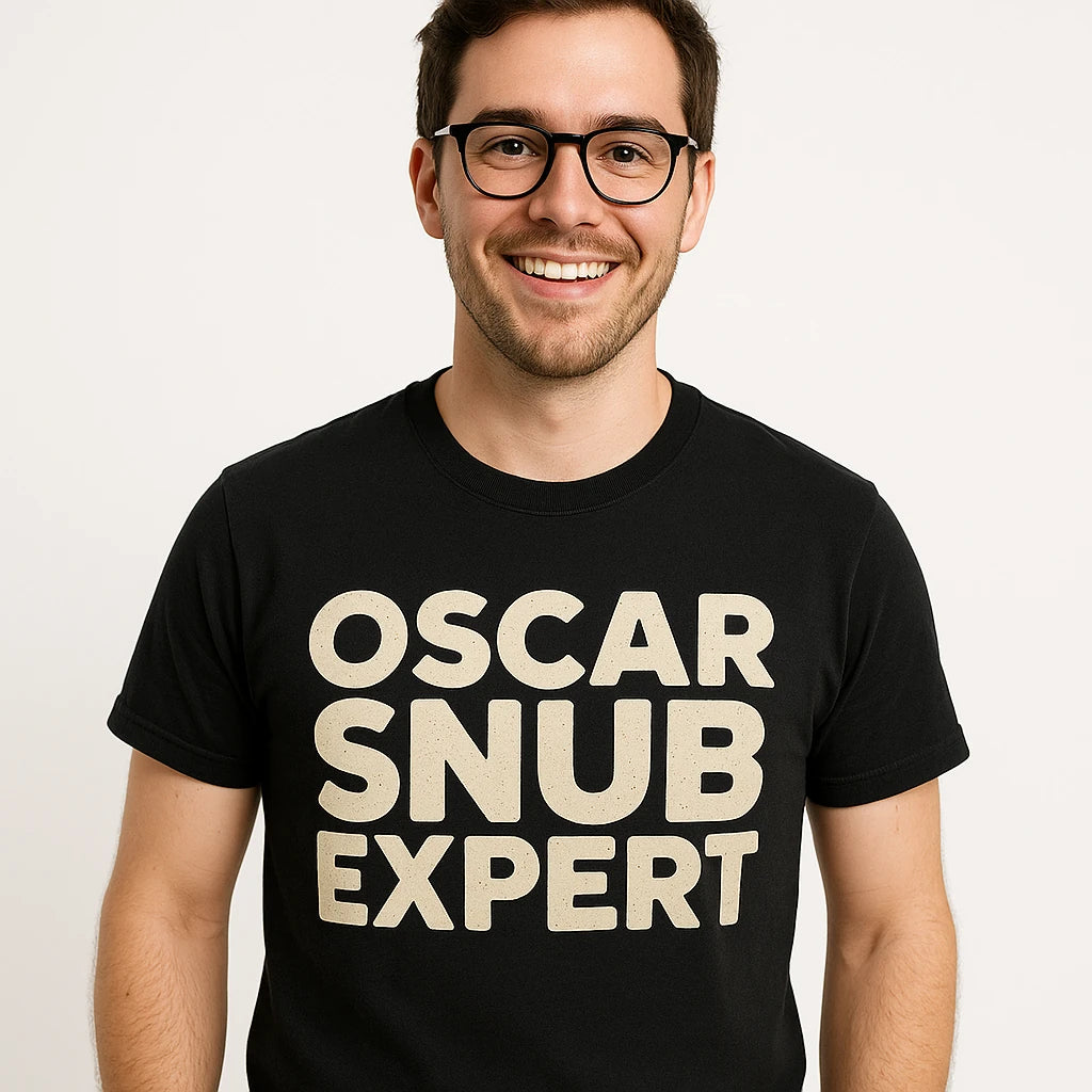 Close-up of the "Oscar Snub Expert" beige print on a premium Bella+Canvas black graphic tee
