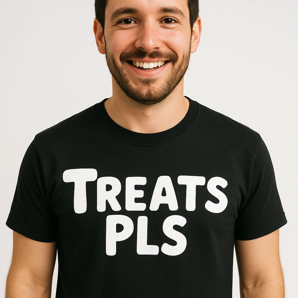 A smiling person with short dark hair and a beard, wearing a black t-shirt with the text "TREATS PLS" printed in bold white letters. The background is plain and white.