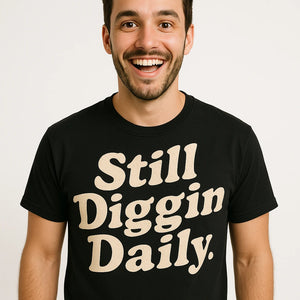 Close-up of the "Still Diggin Daily" cream print on a premium Bella+Canvas black hip hop tee shirts