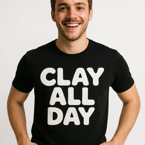 Close-up of the "Clay All Day" white print on a premium Bella+Canvas black sculpting t shirt