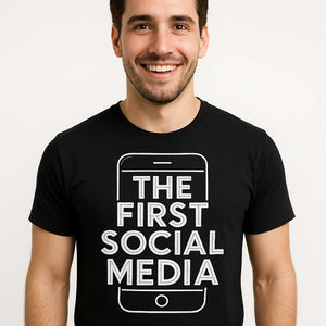 Close-up of the "The First Social Media" white print on a premium Bella+Canvas black smartphone t shirt