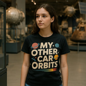 Lifestyle shot of the "My Other Car Orbits" black space science shirts in a real-world setting