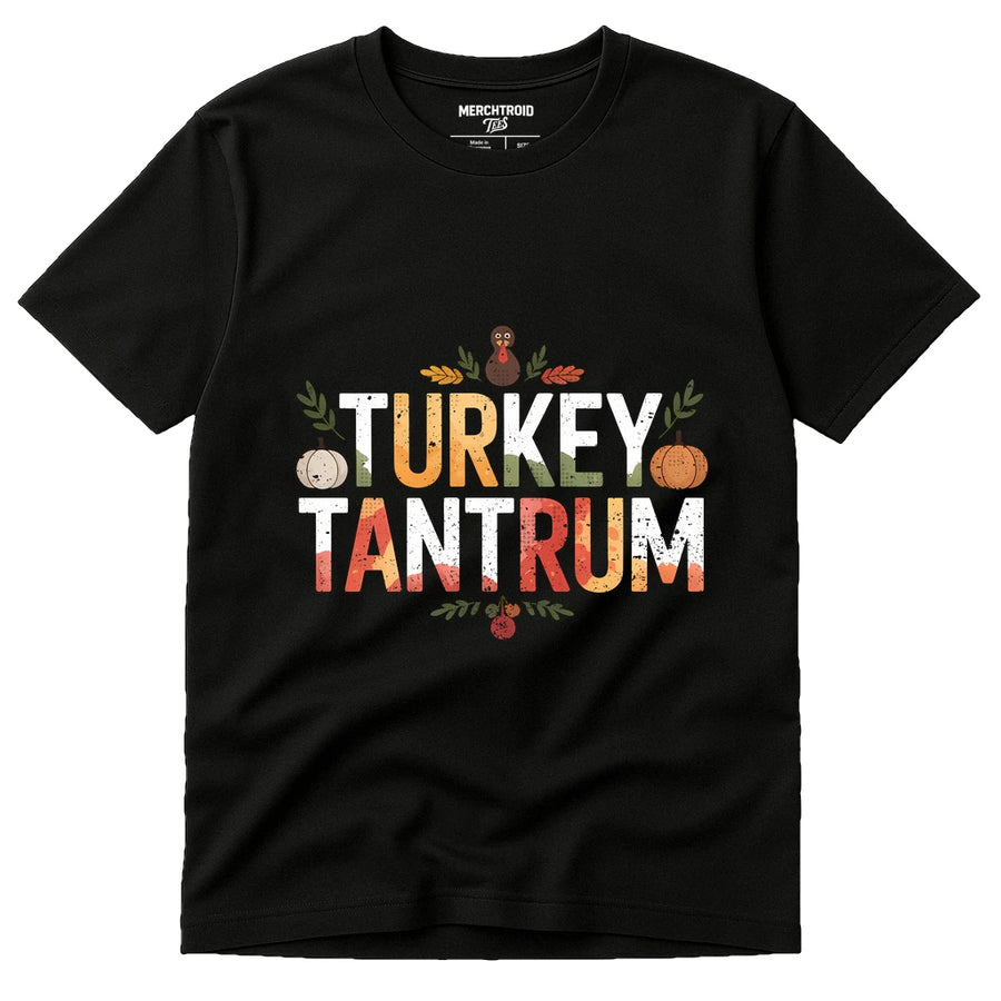 A black t-shirt with the words "TURKEY TANTRUM" printed in large, colorful letters. The design features autumn-themed graphics including a pumpkin, leaves, and a small red turkey illustration. The brand "MERCHTROIOD" is printed on the inside label.