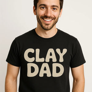 Close-up of the "Clay Dad" beige print on a premium Bella+Canvas black sculpting t shirt