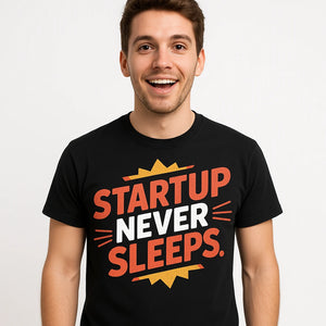 Close-up of the "Startup Never Sleeps" orange print on a premium Bella+Canvas black entrepreneurs t shirt
