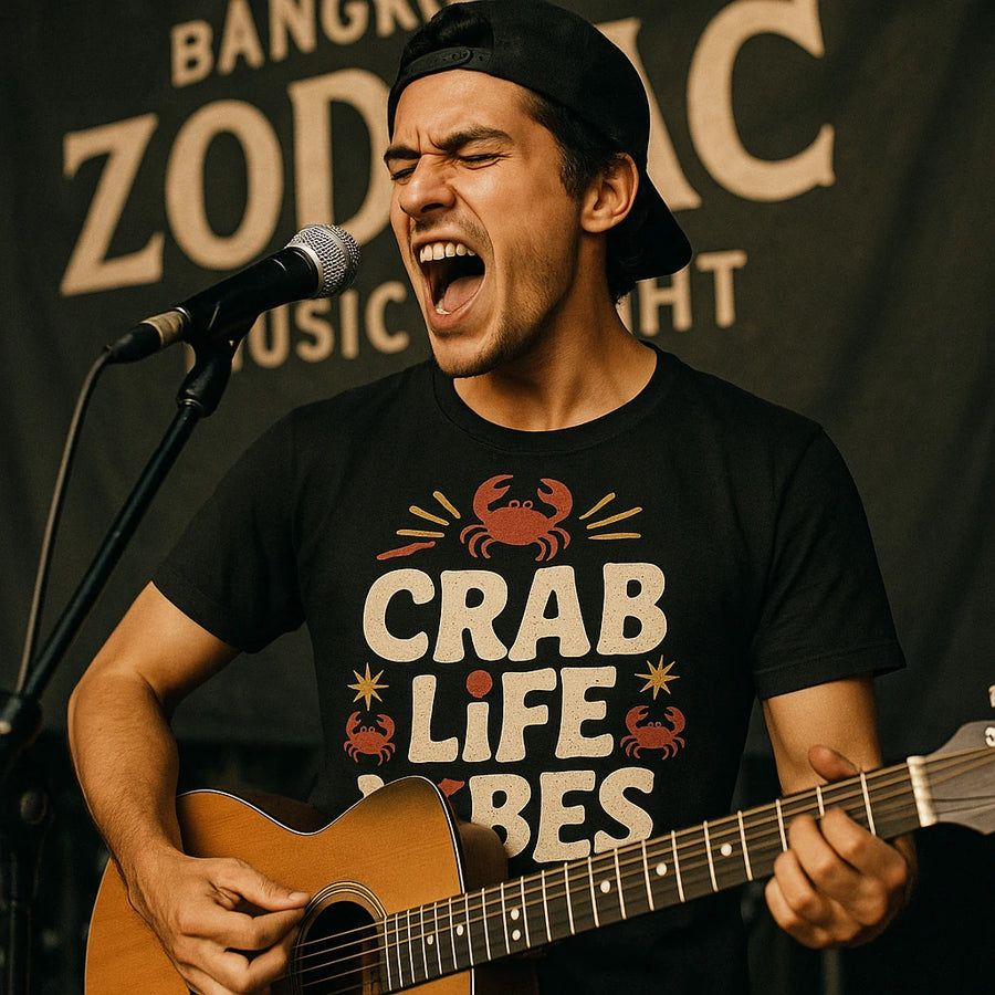 A person wearing a backward cap passionately sings into a microphone while playing an acoustic guitar. They are wearing a black T-shirt with a crab design and the text "CRAB LIFE VIBES." The background has the words "BANGKOK ZODIAC MUSIC NIGHT."