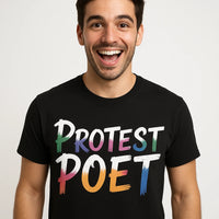 A person with short dark hair is smiling widely at the camera, wearing a black T-shirt with the words 
