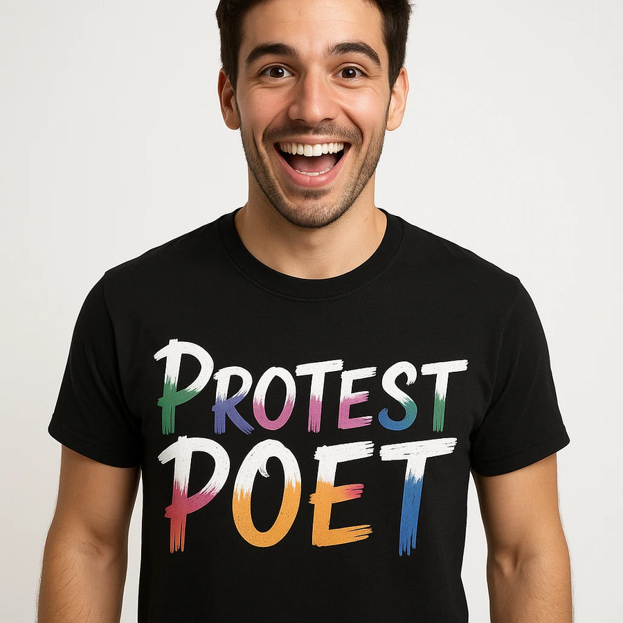 A person with short dark hair is smiling widely at the camera, wearing a black T-shirt with the words "PROTEST POET" in colorful, artistic lettering.