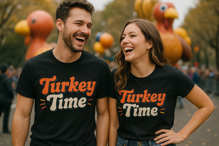 A man and a woman are standing side by side, both laughing. They are wearing matching black T-shirts that read "Turkey Time" in red and white text. In the background, there are large inflatable turkeys and trees, indicating a festive outdoor event.