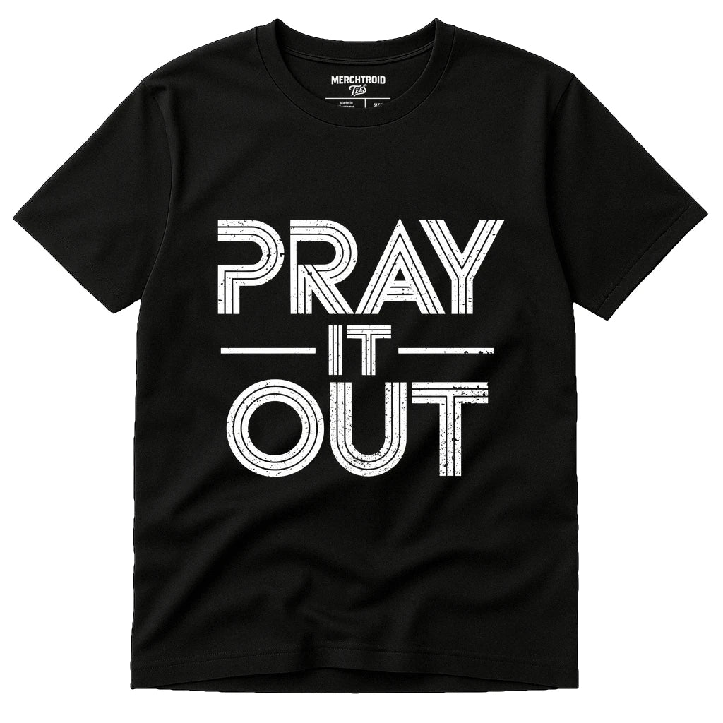 A black T-shirt with bold, white text reading "PRAY IT OUT" in a distressed font. The shirt label shows sizes available, and the brand is "MERCHTROID."
