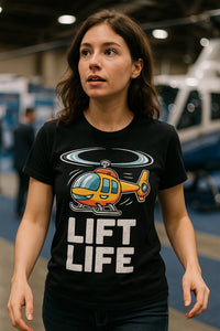 A person with long brown hair is wearing a black T-shirt featuring a colorful cartoon helicopter and the text 