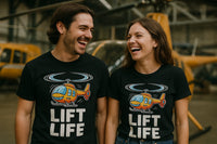 A man and a woman are standing side by side, both wearing black T-shirts featuring a cartoon helicopter and the text 