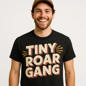 Close-up of the "Tiny Roar Gang" beige print on a premium Bella+Canvas black bobcats t shirt