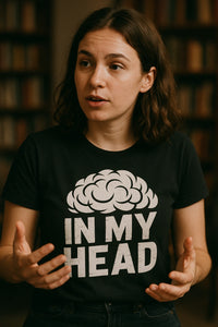A person with shoulder-length brown hair, wearing a black T-shirt that features a brain graphic above the text 