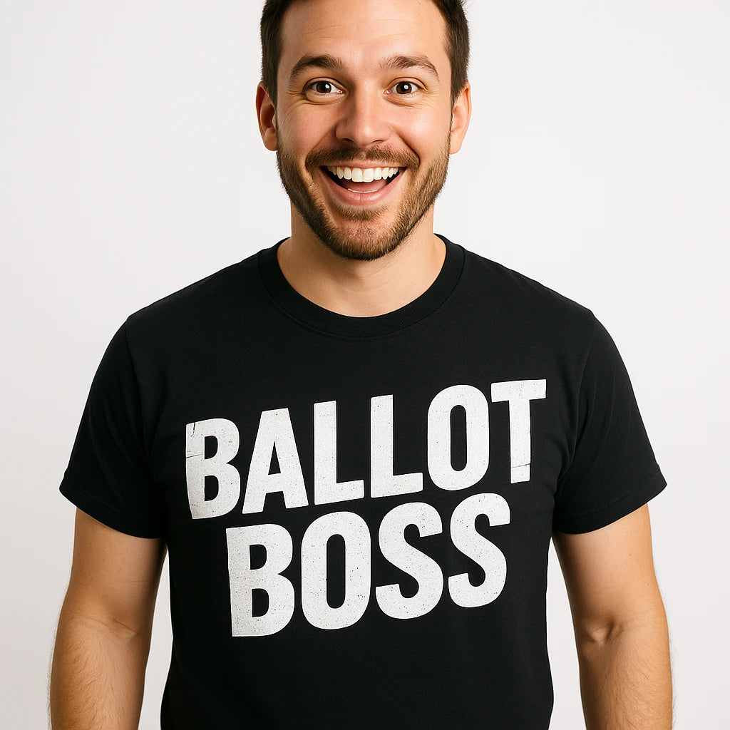 A smiling person with short dark hair and a beard is wearing a black T-shirt with the words "BALLOT BOSS" printed in bold white letters. They are standing against a plain white background.