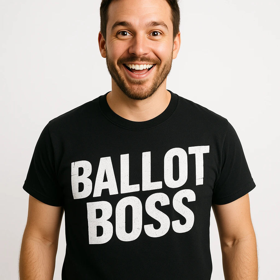 A smiling person with short dark hair and a beard is wearing a black T-shirt with the words "BALLOT BOSS" printed in bold white letters. They are standing against a plain white background.