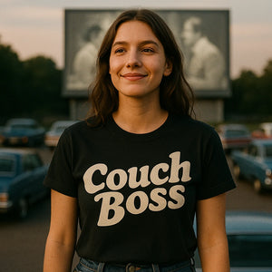 Lifestyle shot of the "Couch Boss" black graphic tee in a real-world setting