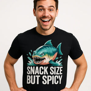Close-up of the "Snack Size But Spicy" cream print on a premium Bella+Canvas black single piranha head t shirt