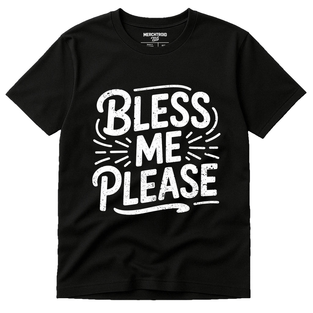 A black t-shirt with bold white text reading "Bless Me Please" in a playful font with decorative elements around the words.