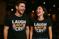 A man and a woman are laughing together, both wearing matching black t-shirts with the text 