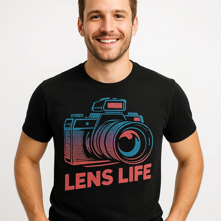 A smiling person wearing a black t-shirt with a colorful graphic of a camera and the text "LENS LIFE" printed on it. The background is plain white.