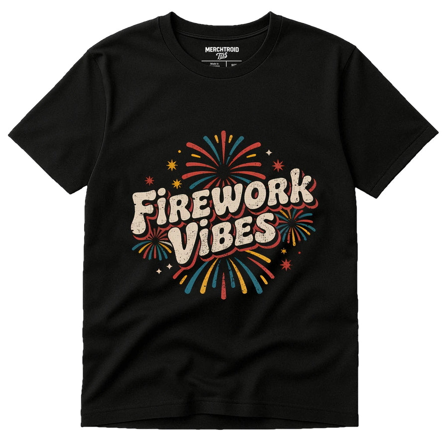 A black t-shirt featuring colorful illustrations of fireworks around the bold, stylized text "Firework Vibes" in the center. The shirt has a casual, festive design.