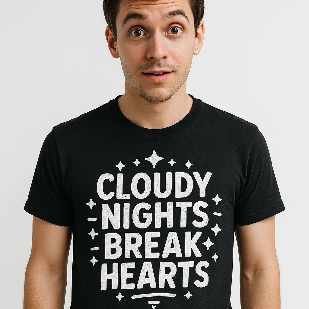 A person wearing a black t-shirt with bold white text that reads "CLOUDY NIGHTS BREAK HEARTS." The person has a surprised or intrigued expression, with short dark hair and is standing against a plain white background.