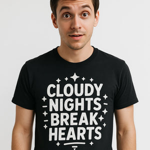 Close-up of the "Cloudy Nights Break Hearts" white print on a premium Bella+Canvas black stargazing t shirt