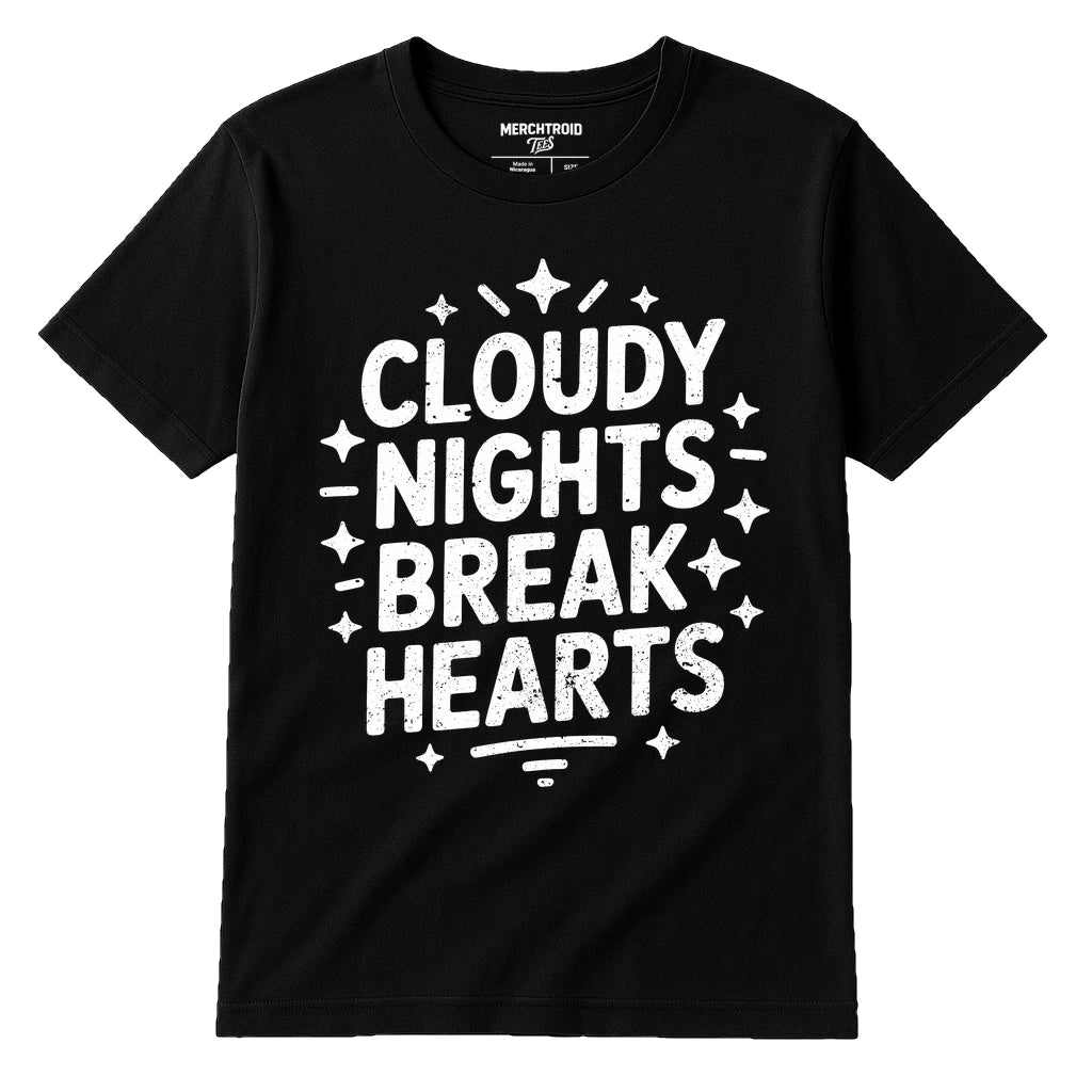 A black t-shirt with bold white text that reads "CLOUDY NIGHTS BREAK HEARTS" surrounded by star-like designs. The label at the neck reads "MERCHTROID."