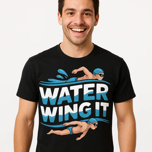 Close-up of the "Water Wing It" cream print on a premium Bella+Canvas black swimming t shirt men