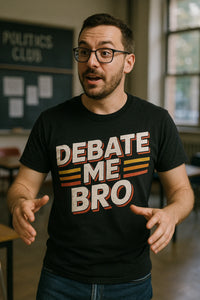 A person with short hair and a beard is wearing glasses and a black T-shirt with the text 