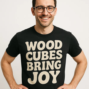 Close-up of the "Wood Cubes Bring Joy" beige print on a premium Bella+Canvas black board game tee shirts
