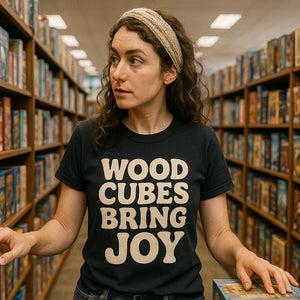 Lifestyle shot of the "Wood Cubes Bring Joy" black board game tee shirts in a real-world setting